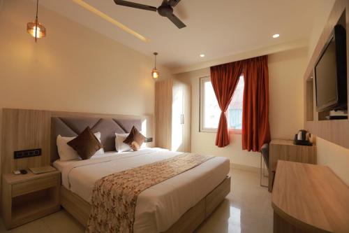 新德里Zed Hotel - IGI Airport Delhi的酒店客房,配有床和电视