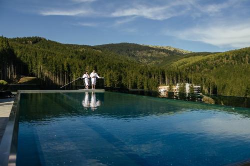 布克维Rest&Ski Spa Resort的两个人站在水库边