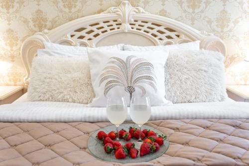 敖德萨Красивая квартира в ЦЕНТРЕ Одессы的床上托盘上放上两杯酒杯和草莓