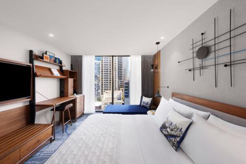 墨尔本Le Méridien Melbourne的配有一张床和一张书桌的酒店客房