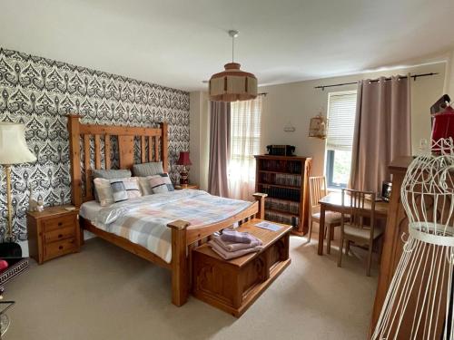 北安普敦Upton Country Park Guest House的一间卧室配有一张床、一张桌子和一张书桌