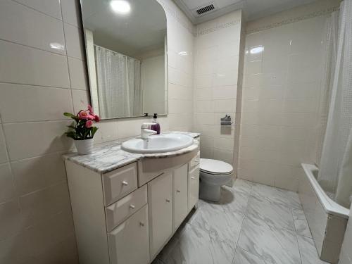 苏埃卡Casa adosada junto a la playa de El Perelló的白色的浴室设有水槽和卫生间。