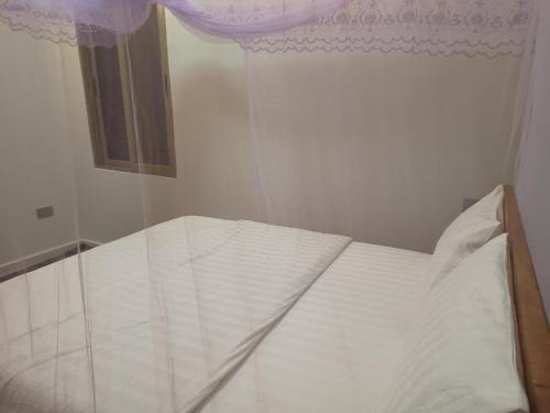 金贾Grand Grove Villa的卧室内的一张白色床,设有窗户