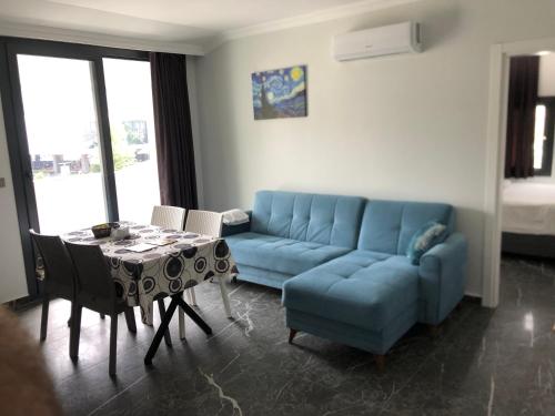 费特希耶Sofya Suites的客厅配有蓝色的沙发和桌子