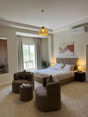 迪拜Halima Shared Housing - Female only的一间大卧室,配有一张床和两把椅子