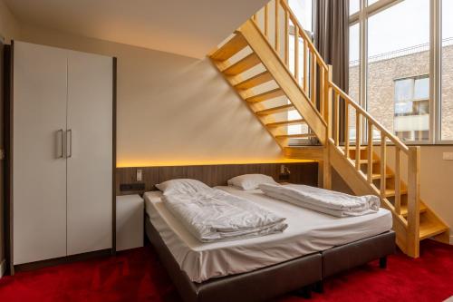 OverpeltHotel De Boskar Pelt的一间卧室设有一张床和一个楼梯