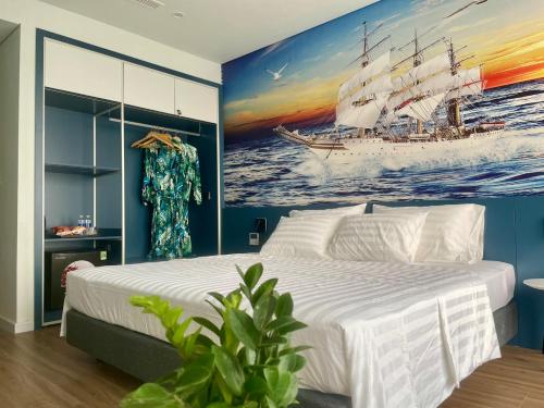 清化Flamingo Hải Tiến的卧室配有一张白色大床和一幅船画