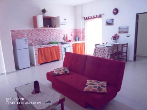 萨尔雷aparthotelboavistacom的一间带红色沙发的客厅和一间厨房