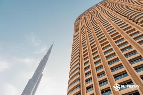 迪拜OSTAY -Address Dubai Mall - The Residence的一座高大的建筑,其顶尖为背景