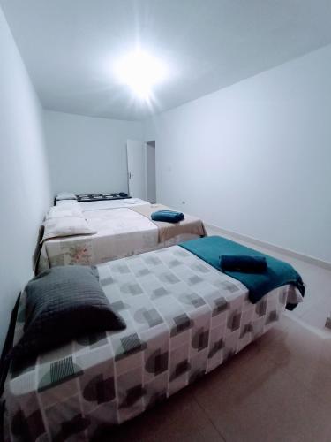 因佩拉特里斯Apartamento Mobiliado no Centro Comercial的两张睡床彼此相邻,位于一个房间里