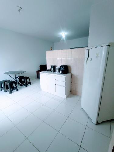 因佩拉特里斯Apartamento Mobiliado no Centro Comercial的白色的厨房配有冰箱和桌子
