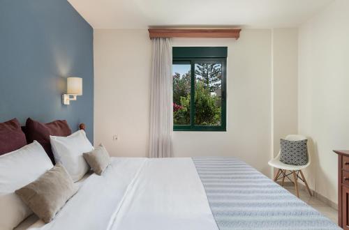 普拉塔尼亚斯Caldera Bay的卧室配有白色的床和窗户。