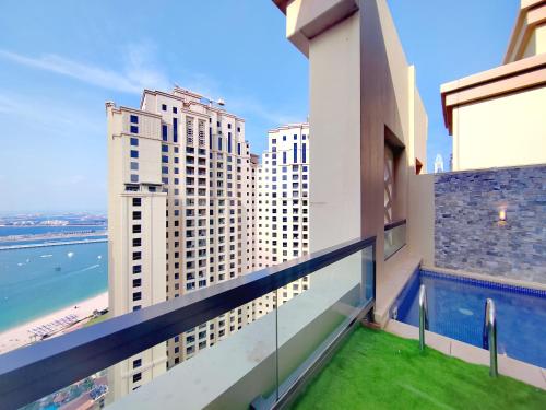 迪拜ELAN RIMAL SADAF Suites的阳台享有大海和建筑的景致。