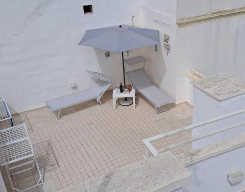 加利波利Cinque terrazze - Casa d'epoca con vista mare的享有带桌子和遮阳伞的天井的顶部景致。