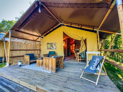 韦尔东的埃斯帕隆拉格朗阁娜露营地的木制甲板上的帐篷,配有桌椅