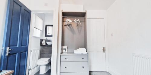 诺丁汉Single Room in Modern House near Nottingham的一间带卫生间和蓝色门的浴室