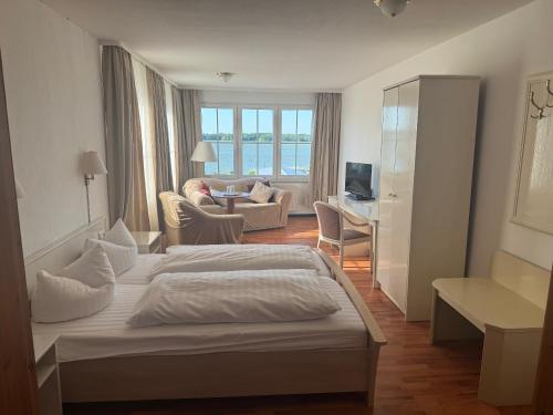 里布尼茨达姆加滕珀尔博登酒店的一间卧室设有一张床和一间客厅。