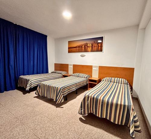 贝尼多姆拉奥罗扎宾馆的配有蓝色窗帘的客房内的两张床