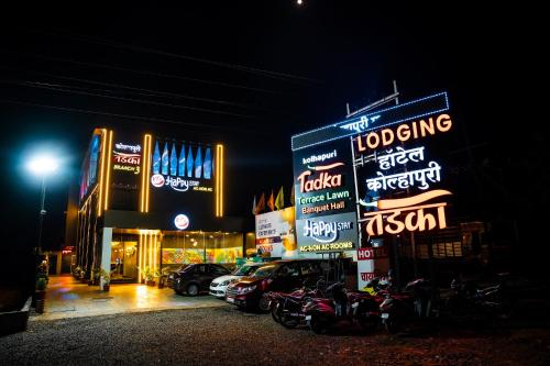 戈尔哈布尔Hotel Happy Stay Kolhapur 2 km from kolhapur airport的一群晚上在建筑物前的标志