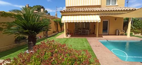 圣佩德罗-德里瓦斯Mi Casa的一座带游泳池和棕榈树的房子
