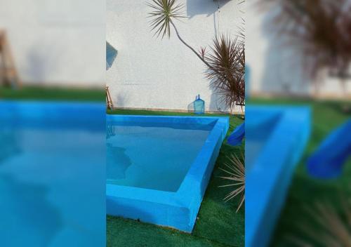 布卢梅瑙Casa aconchego em Blumenau的两幅草地蓝色游泳池的照片