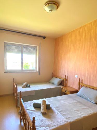 里瓦德奥A casa da Sia的一间卧室设有两张床和窗户。