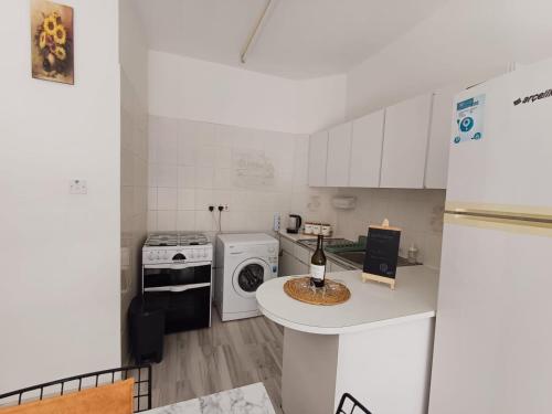 DumlupınarSUNFLOWER APARTMENT的厨房配有白色橱柜和白色冰箱。