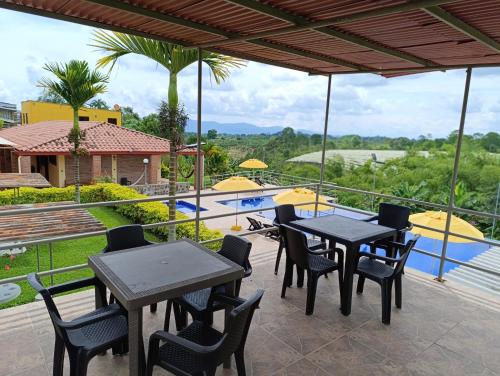 金巴亚Hotel Campestre Los Mangos的一个带桌椅的庭院和一个游泳池