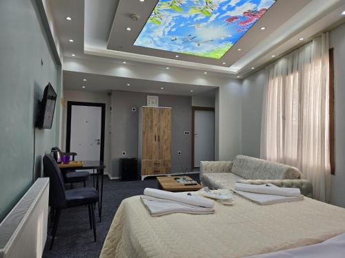 乌沙克Uyu Room Uşak Otel的客房设有床、沙发和桌子。