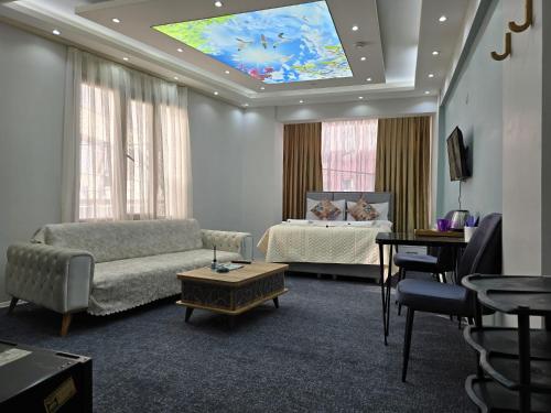 乌沙克Uyu Room Uşak Otel的客厅配有床、沙发和电视。