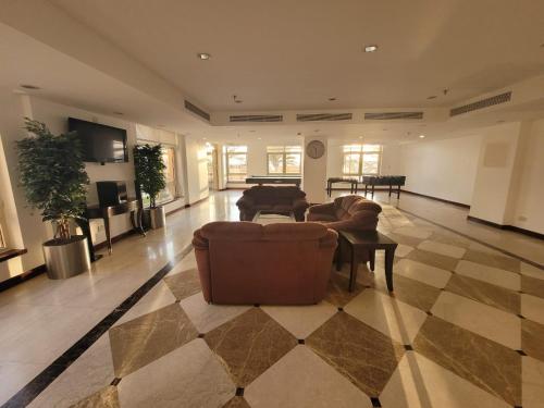 阿卜杜勒国王经济城Lotus Apartments的带沙发和棋盘地板的大型客厅