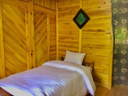 老街市Lysa House的卧室配有木墙内的一张床