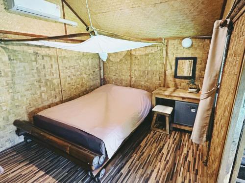 拜县拜县乡村小屋酒店的一间小卧室,配有一张床和一张书桌