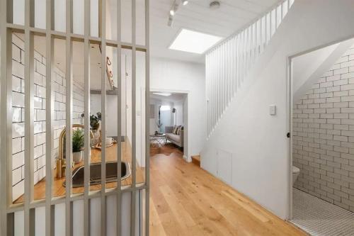 悉尼Balmain Central Cozy 3 bed house的客厅拥有白色的墙壁和楼梯
