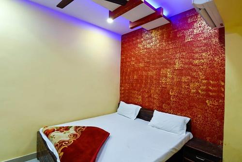 坎普尔Hotel Atithi Galaxy Kanpur Near Railway Station Kanpur - Wonderfull Stay with Family的一间设有一张红色墙壁的床的房间