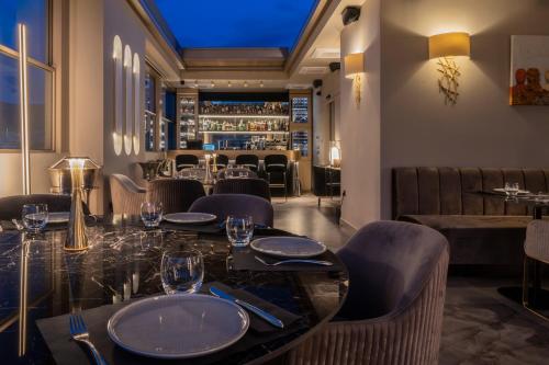 雅典Heritage Hill Hotel的一间带桌椅的餐厅和一间酒吧