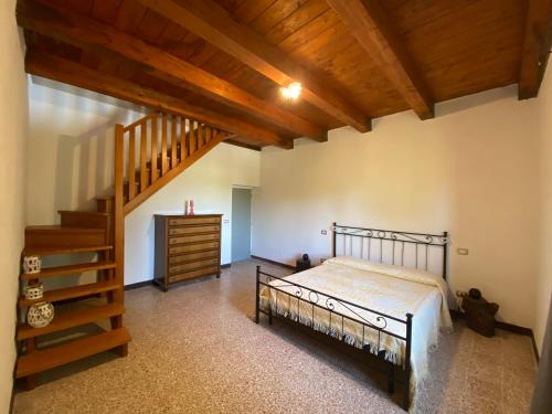 托迪Colle Costanza的一间卧室设有一张床和木制楼梯。