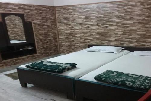 瓦拉纳西Hotel Teerth Guest House Inn Varanasi的一间卧室配有两张床和镜子