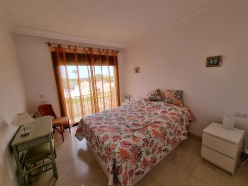 圣哈维耶尔Casa Verano in Roda Golf and Beach Resort Mar Menor的一间卧室设有一张床、一个窗口和一张桌子