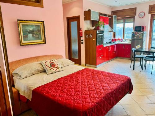 那不勒斯Napoli Centro的一间带红色床的卧室和一间厨房