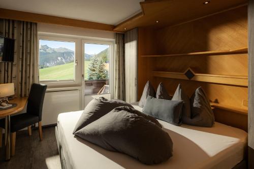 贝旺Alpen Apartments Austria的一间卧室设有一张大床和窗户