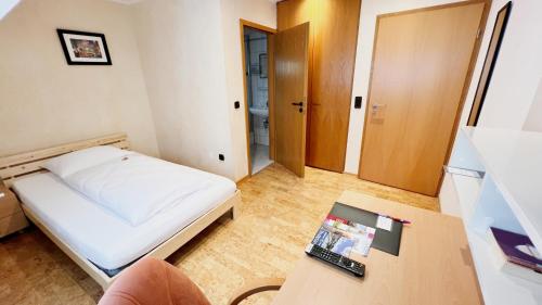 圣戈阿尔Hotel zur Loreley - Garni的小房间设有一张床和一张桌子