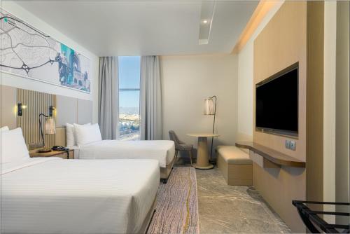 马斯喀特IntercityHotel Bawshar Muscat的酒店客房设有两张床和一台平面电视。