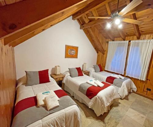 圣马丁德洛斯Apart Hotel Orilla Mansa by Visionnaire的配有木天花板的客房设有两张床。