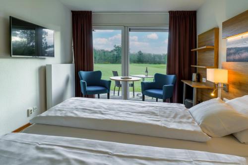 卡兰茨奥赫霍恩酒店的卧室配有一张床和一张桌子及椅子