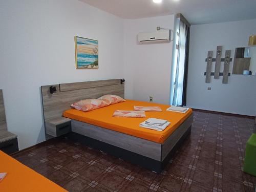 切尔诺莫雷茨Coral Family Hotel的一间卧室配有一张带橙色床罩的床