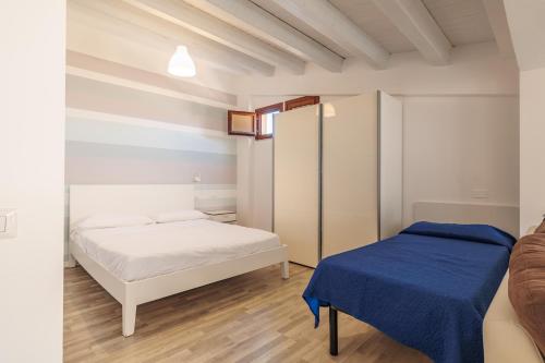 卡斯泰拉马莱Marina di Petrolo Apartments的一间卧室配有两张床和蓝色毯子