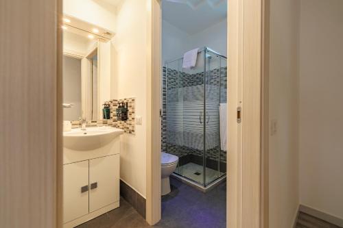 卡斯泰拉马莱Marina di Petrolo Apartments的一间带水槽、卫生间和淋浴的浴室