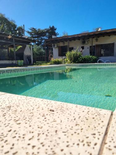 查斯科穆斯Tordillo B&B的一座房子前面的清澈 ⁇ 蓝的游泳池