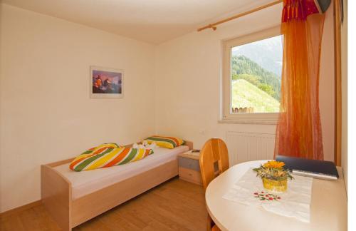 圣马蒂诺Gasthaus Jaufenblick的一间卧室设有两张床、一张桌子和一个窗口